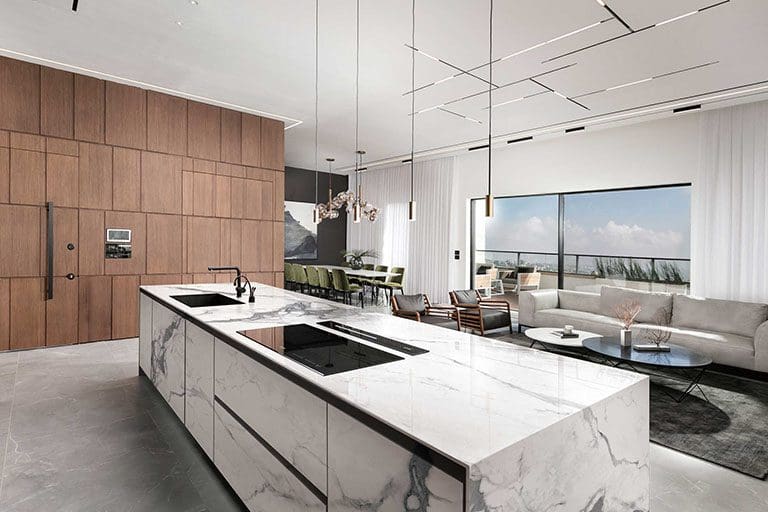 Modern kitchen with natural stone countertop, wooden cabinets, and a view of the ocean through large windows.