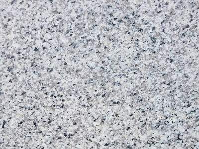 Close-up texture of a natural stone granite surface with speckled black and white patterns.