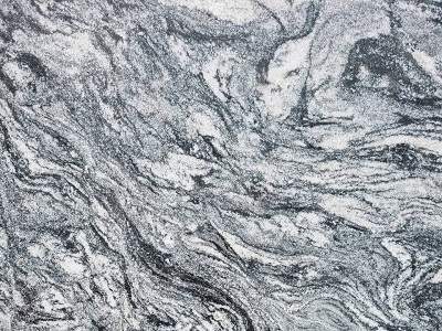 Close-up texture of a natural stone countertop with intricate swirls of black, white, and gray patterns.