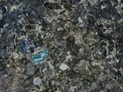 Close-up of a Natural Stone countertop with small, embedded blue and turquoise minerals.