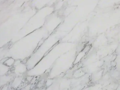 Close-up of a white natural stone surface with gray veining.