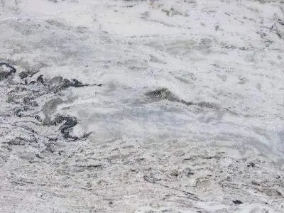 Close-up view of a textured natural stone surface with patterns resembling flowing water or melted ice.