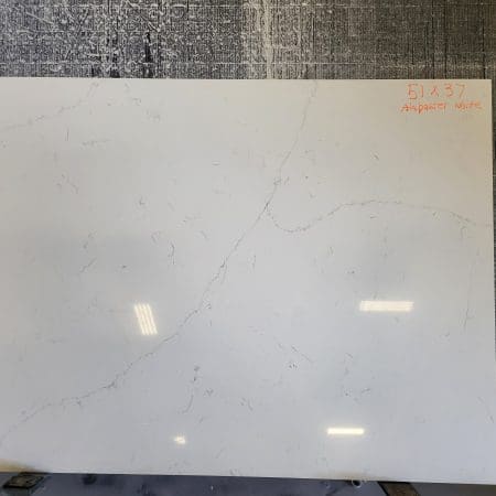 Large white marble countertop remnants with gray veins, displayed in a workshop setting with visible dimensions written on the top right corner.