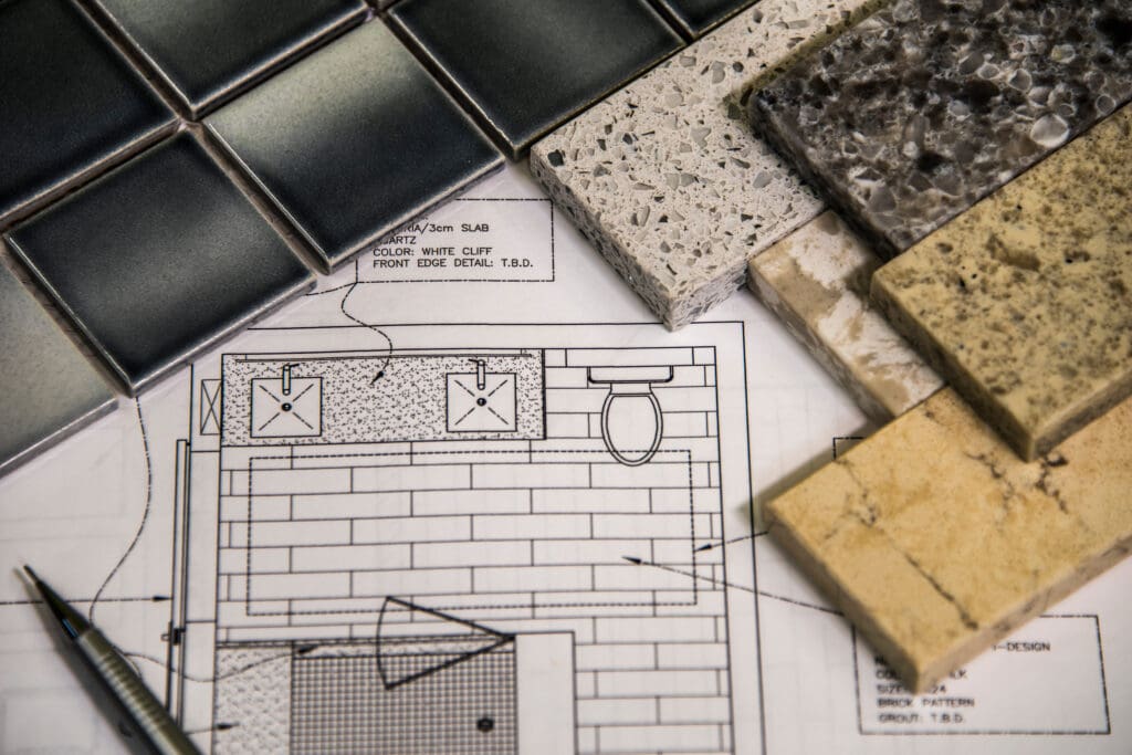 Architectural floor plan with material samples and tile pieces.