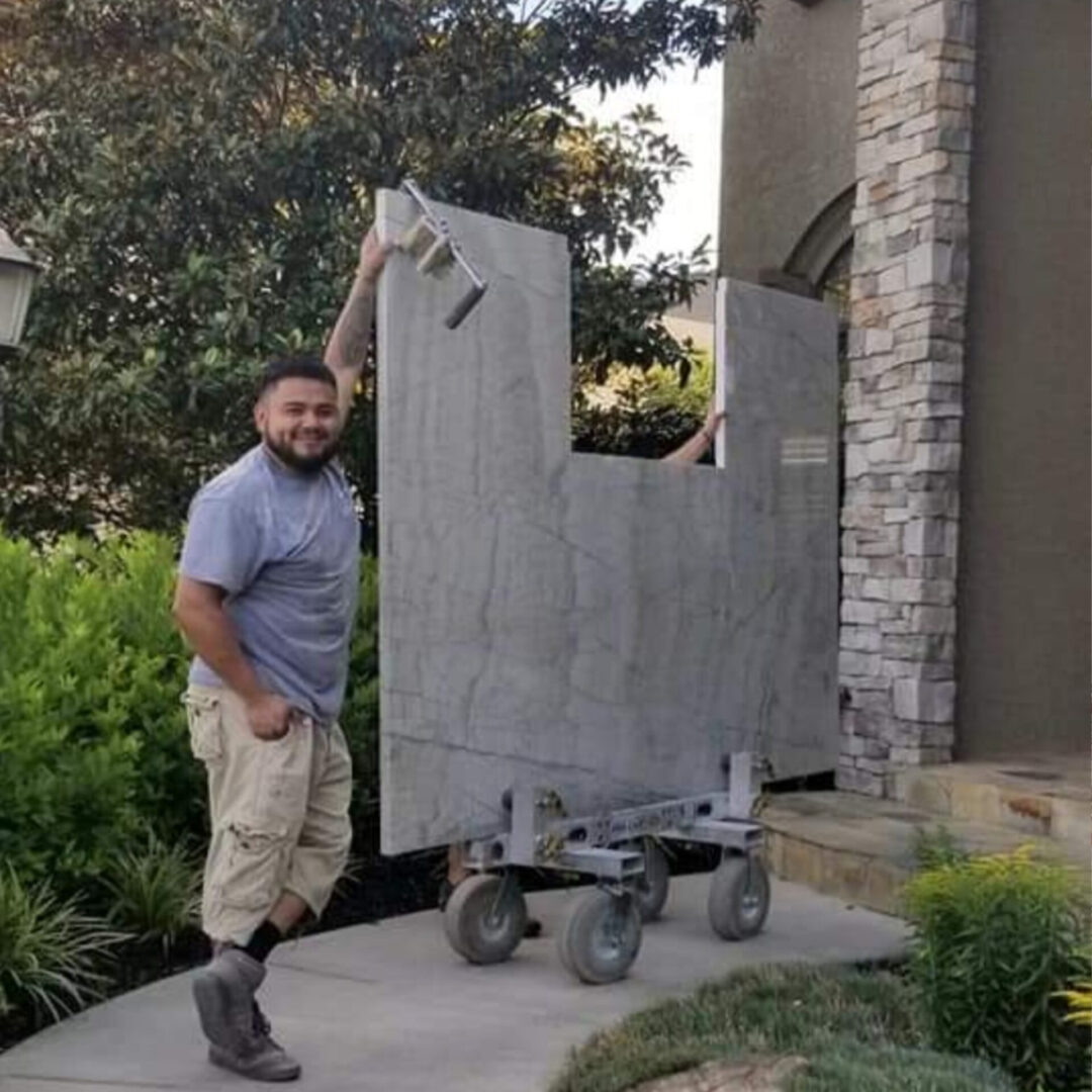 Oliver, shop manager at Any Top Shop, transporting large stone slabs for a countertop installation project.