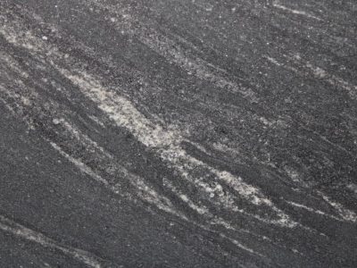 Close-up of textured dark gray stone with light streaks.