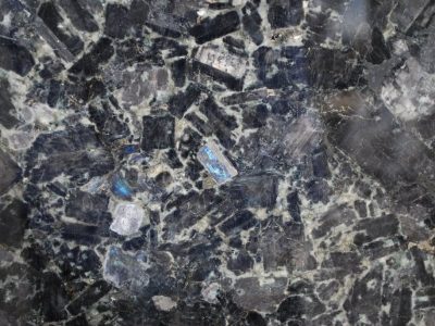 Close-up of a polished blue labradorite stone surface with iridescent flashes.