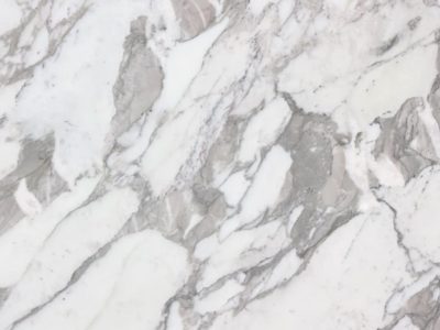 Close-up of Calacatta Vagli marble featuring dramatic gray veining, layered stone movement, and natural variation across a white marble surface.