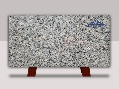 Polished granite slab displayed on wooden stands.