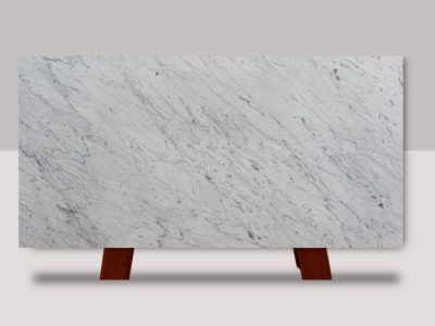 Full slab of Calacatta Carrara marble featuring a white background with soft gray veining and subtle natural stone movement.
