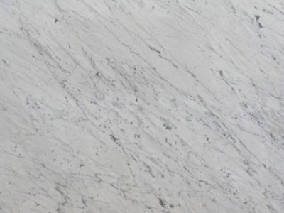 Close-up of Calacatta Carrara marble showcasing a white background with fine gray veining and natural stone detail.