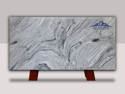 Polished gray marble slab with natural veining, displayed on wooden stands.