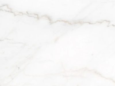 Close-up of Crema Delicato marble showcasing soft gray veining, warm cream undertones, and natural stone variation across a light marble surface.
